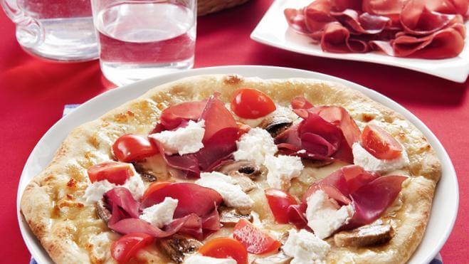 Pizza mozzarella, fromage de chèvre, bresaola, champignons et tomates cerises
