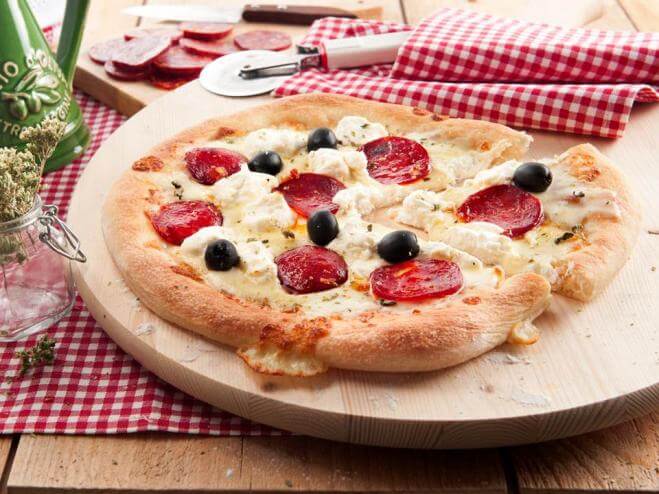 Pizza mit Mozzarella, Ricotta, Oliven und scharfer Salami